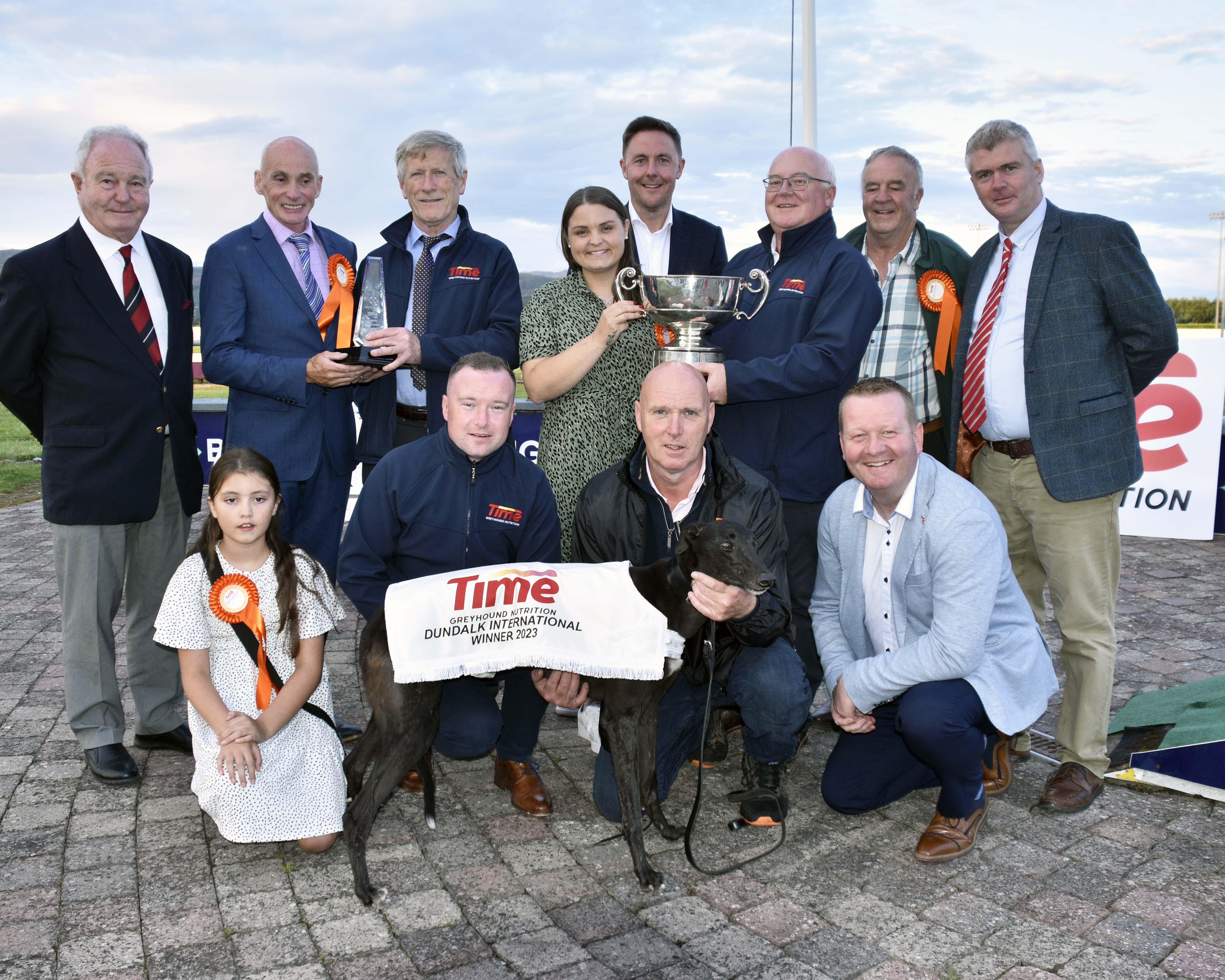 William Rigney presents the trophy to Marissa Molloy after Raha Mofo won the final of the 2023 Time Dundalk International and John Fox presents a replica trophy to Stephen Molloy. Also included are Leon Blanch Chief Commercial Officer GRI, Derek Frehill Director Of Racing GRI, Pat Herbert GRI, Shane Rigney Time, trainer Murt Leahy, handler Stephen Dunne and Leo McAuley Chairman Dundalk Track.  