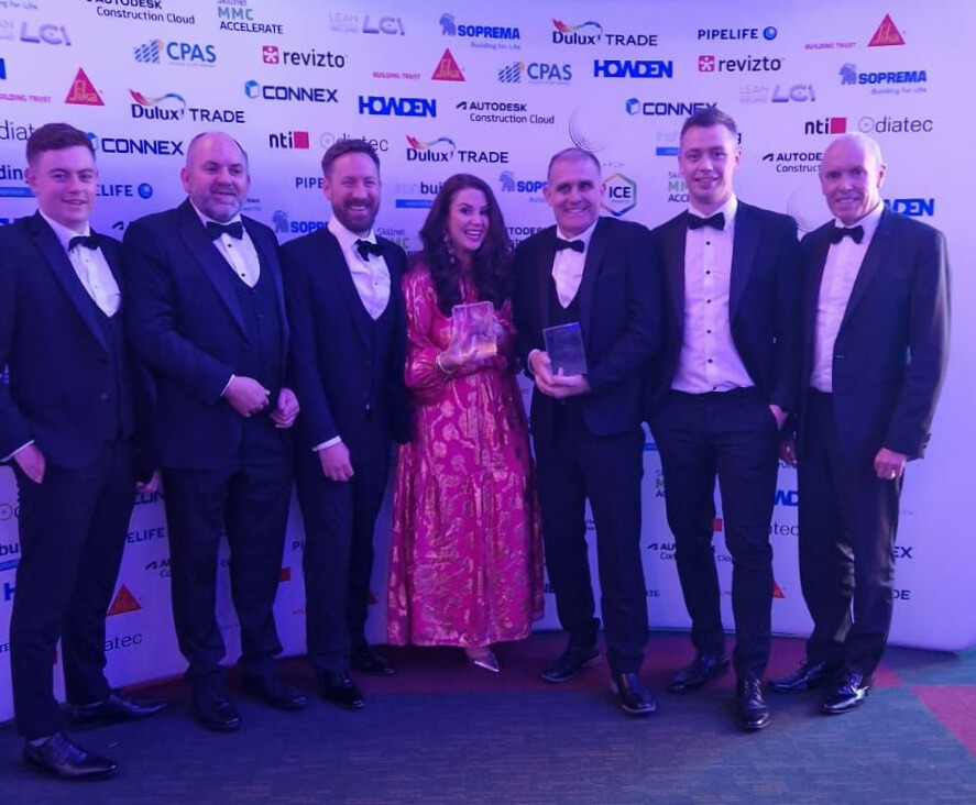 Image showing a group of people involved in the redevelopment project at Shelbourne Park holding two awards following the  double win at the 2025 Irish Construction Excellence Awards